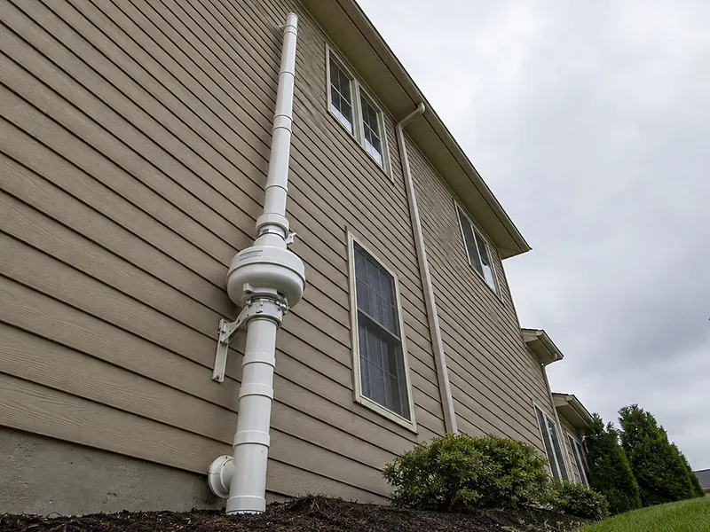 Complete exterior radon mitigation system on an Eau Claire-area home