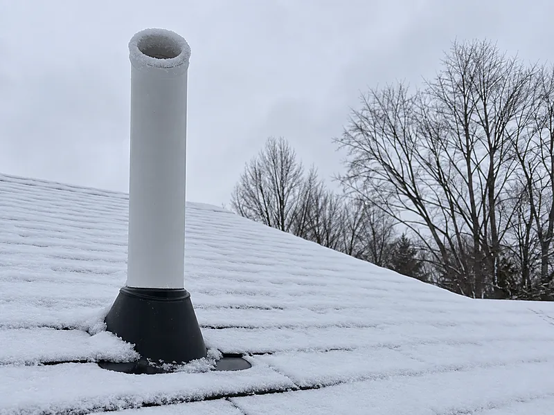 Radon vent stack above a snow-covered Wisconsin roof